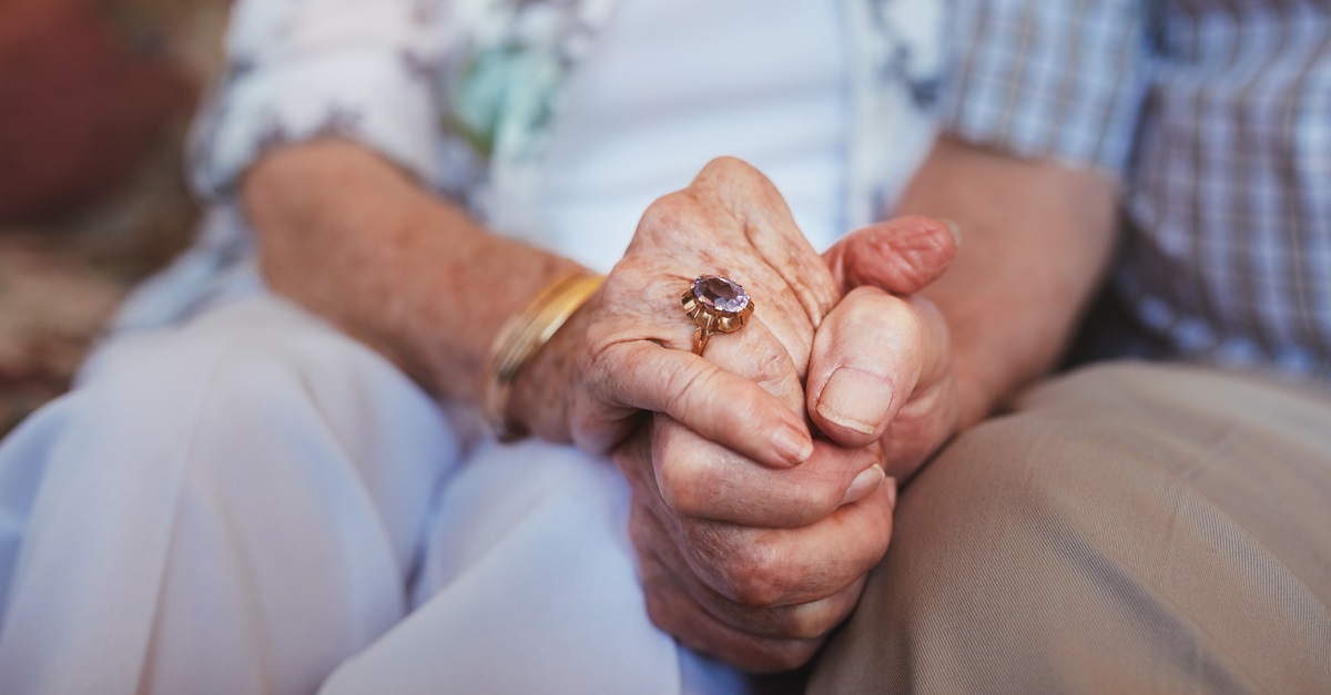 Elderly couple holding hands