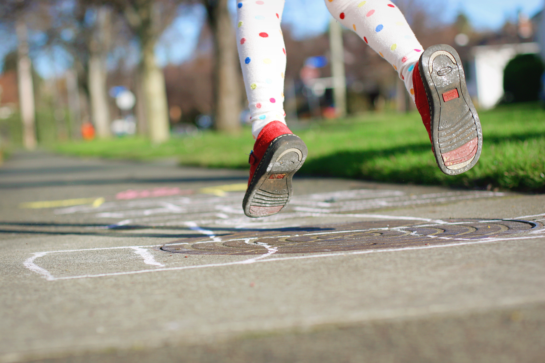 girls-legs-in-midair-hoping-along-the-sidewalk-and-playing-hope-scotch-leggings-and-red-shoes-for_t20_a8mbdE.jpg