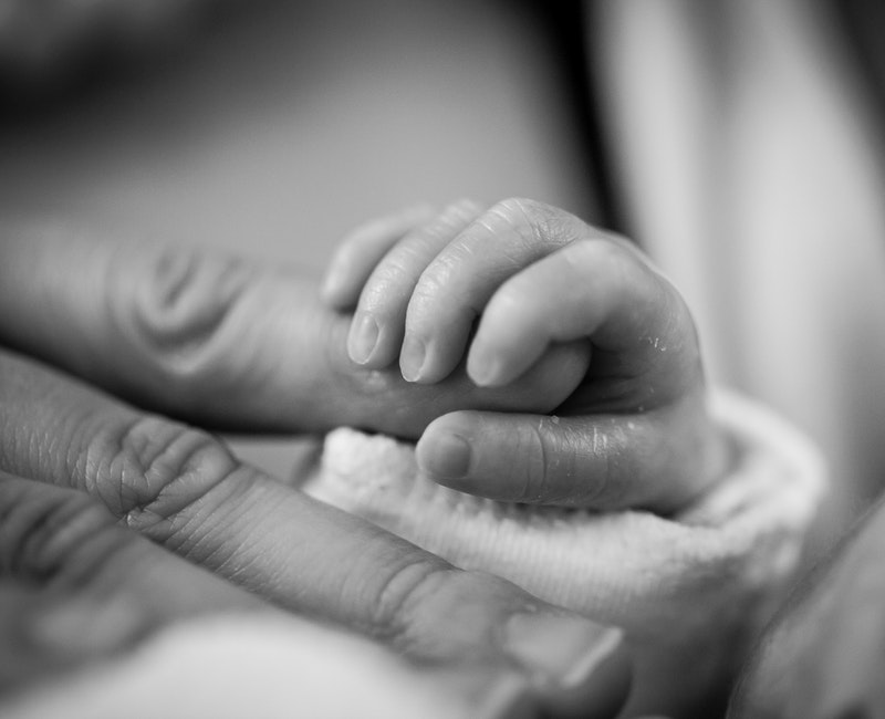 grayscale-photography-of-baby-holding-finger-208189.jpg