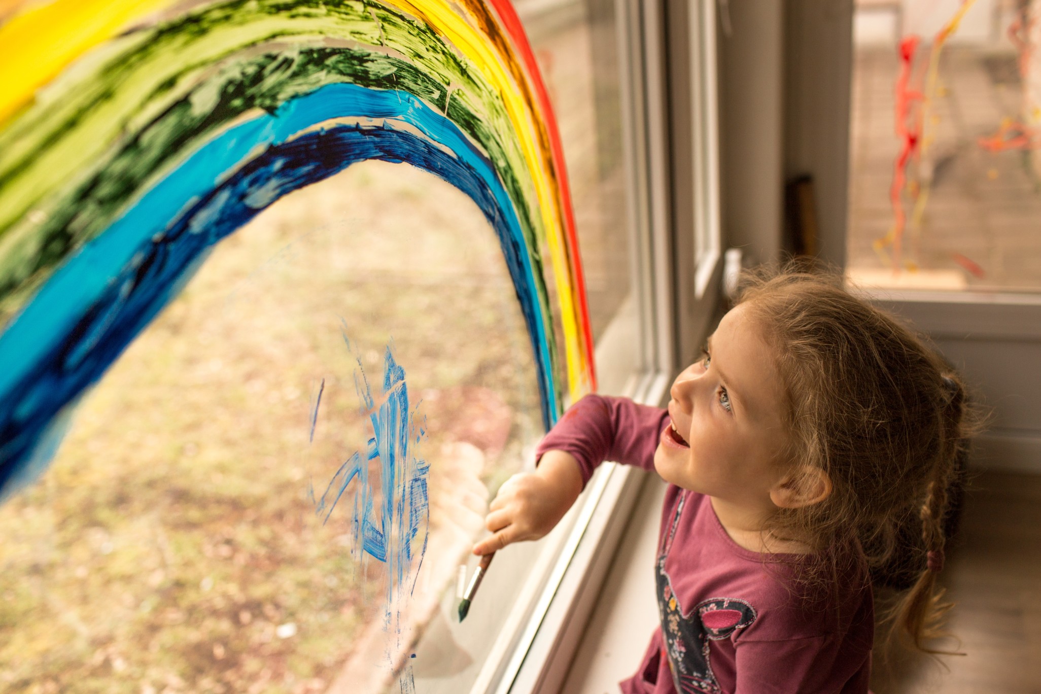 happy-child-girl-painting-blue-color-under-vibrant-rainbow-on-window-during-social-distancing-while_t20_0XOQok.jpg