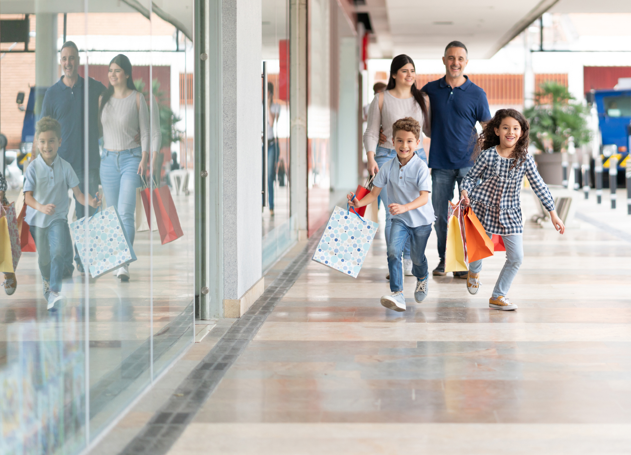 Beautiful couple with their two kids running around at the mall