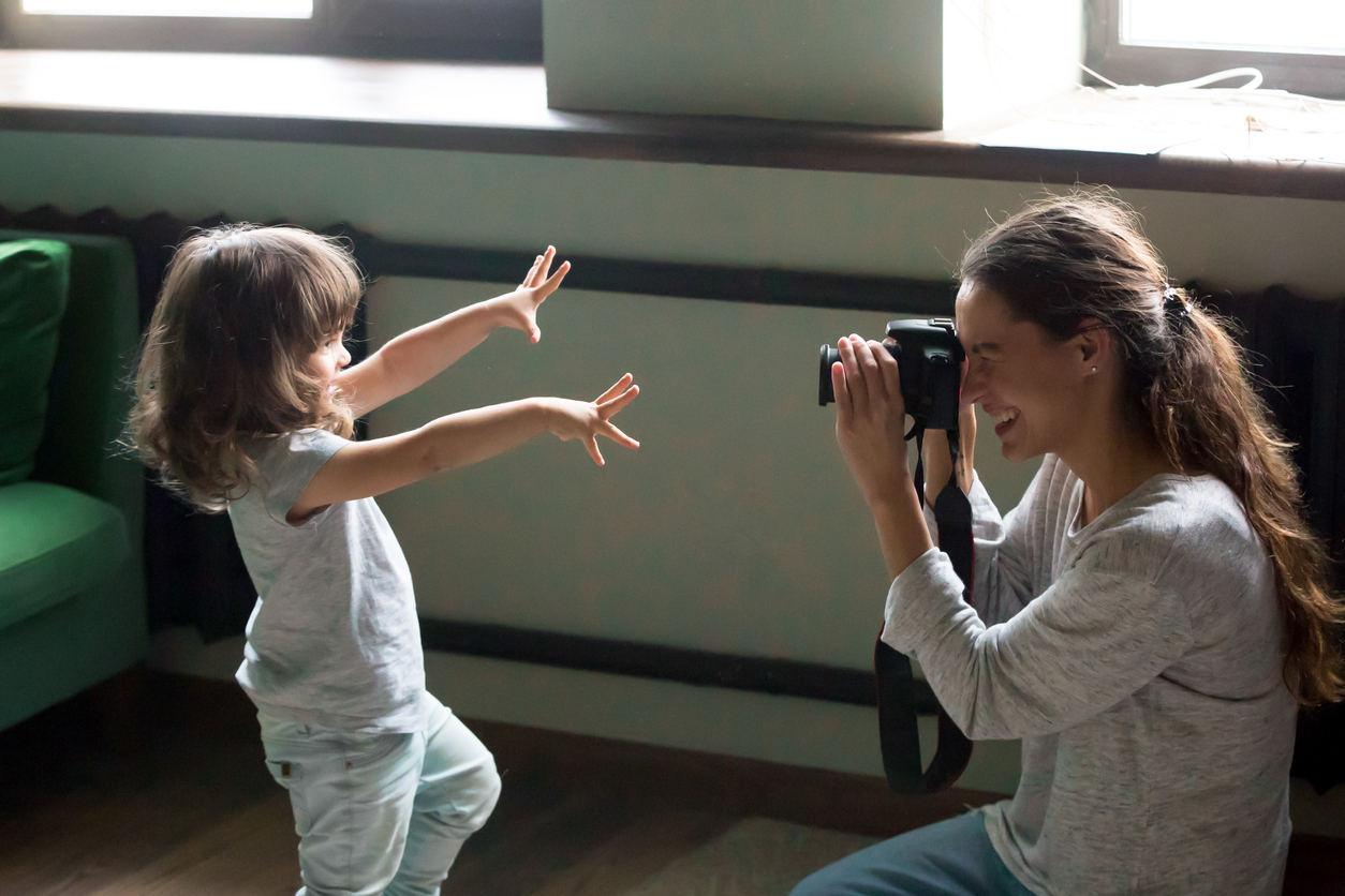 Mom photographer making photo of kid daughter on digital camera