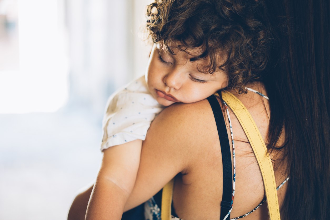 Mother holding her sleeping son