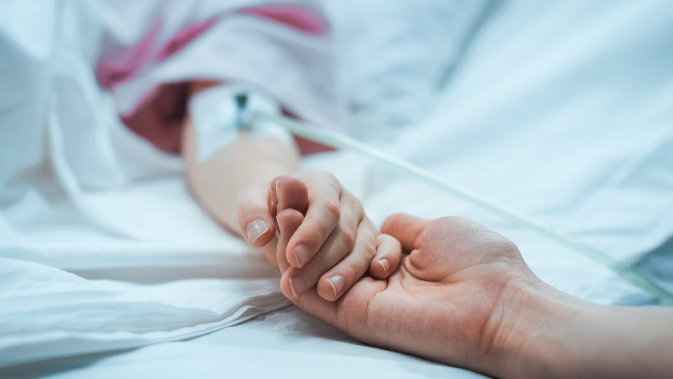 Holding hand in hospital bed