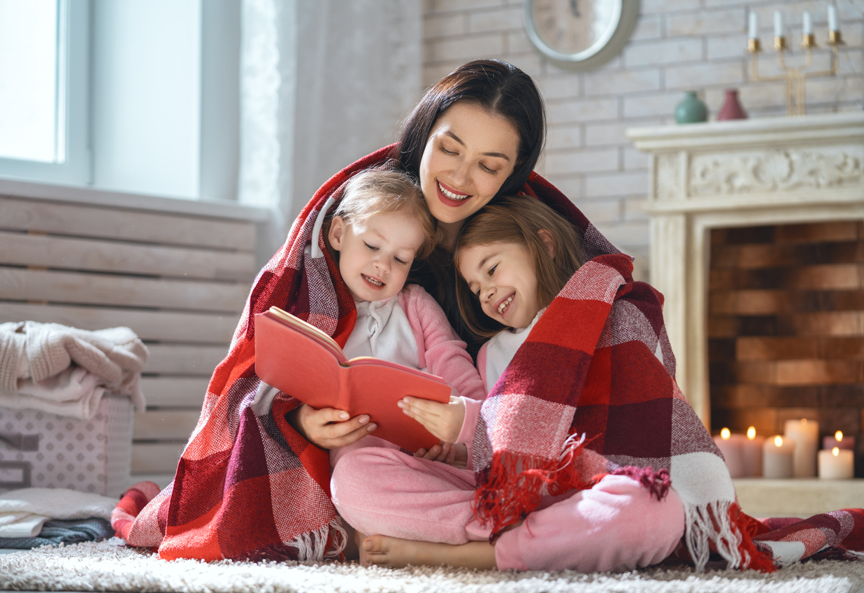 mother reading a book to her daughters