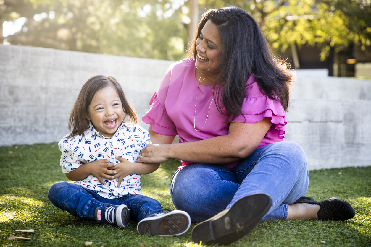 Young Mexican Mom Playing with Down's Syndrome Son in Park