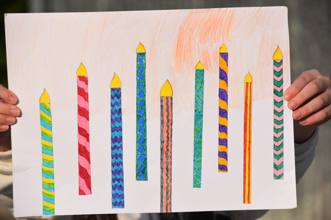 A girl presents a drawing of Chanukah candles