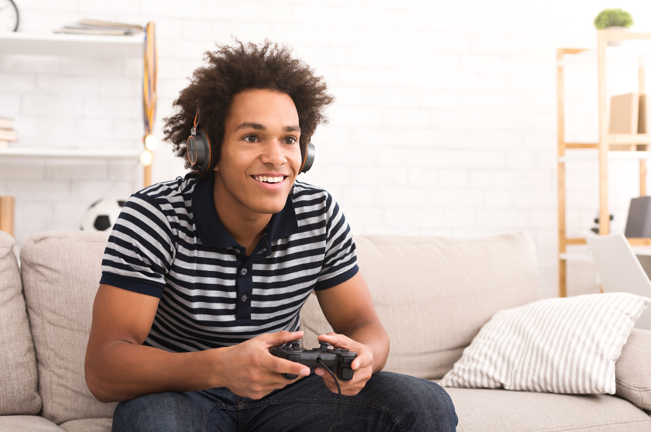 African-american teenager playing video games at home