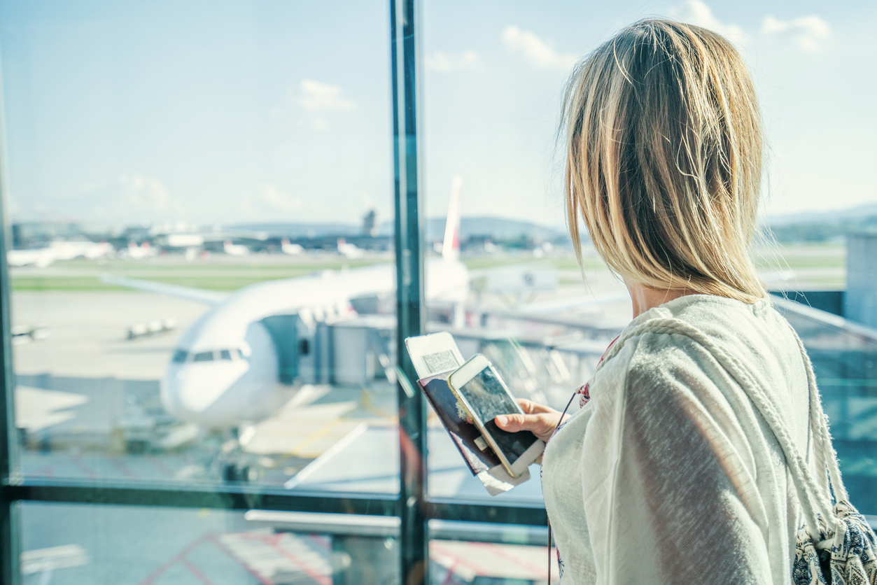 Female at airport in terminal waiting for departure flight