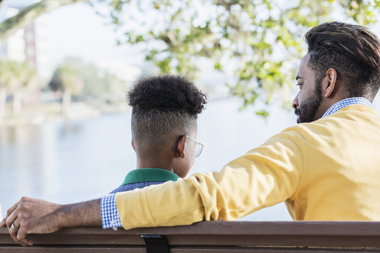 Mixed race father and teenage son city on waterfront