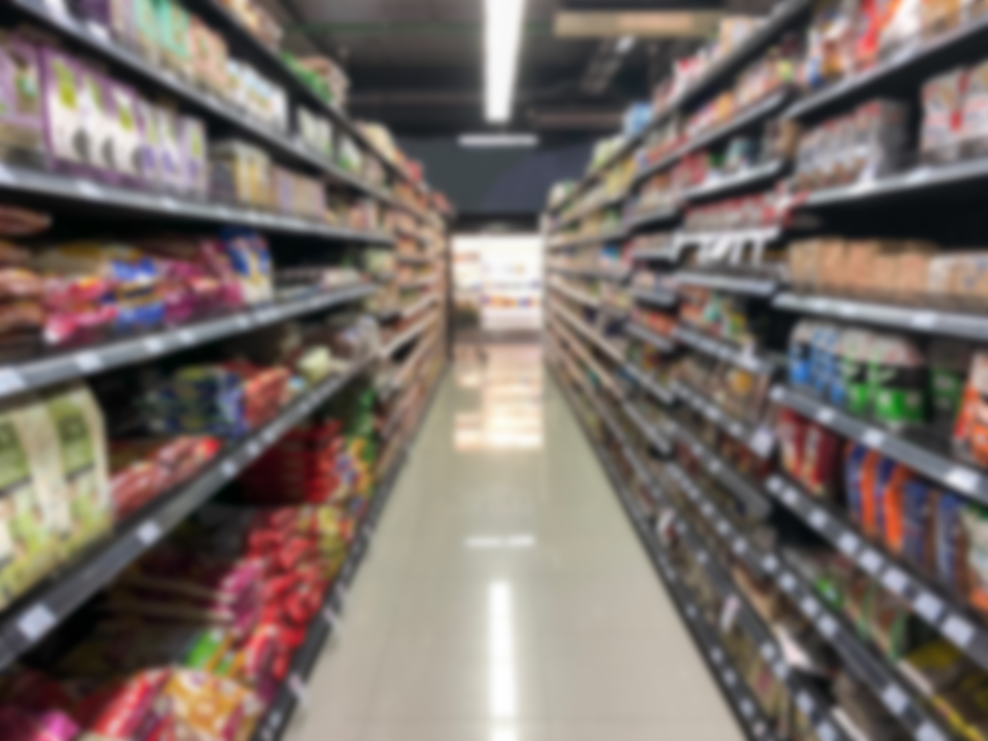 Abstract blurred modern retail supermarket aisle shelves with dark color theme