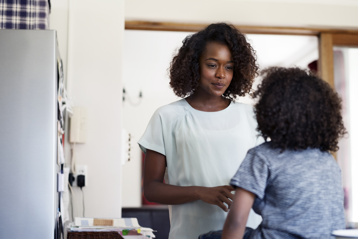 Young woman talking to son at home