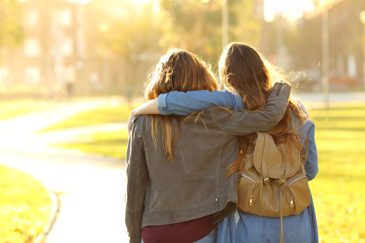 Affectionate friends walking at sunset in a park