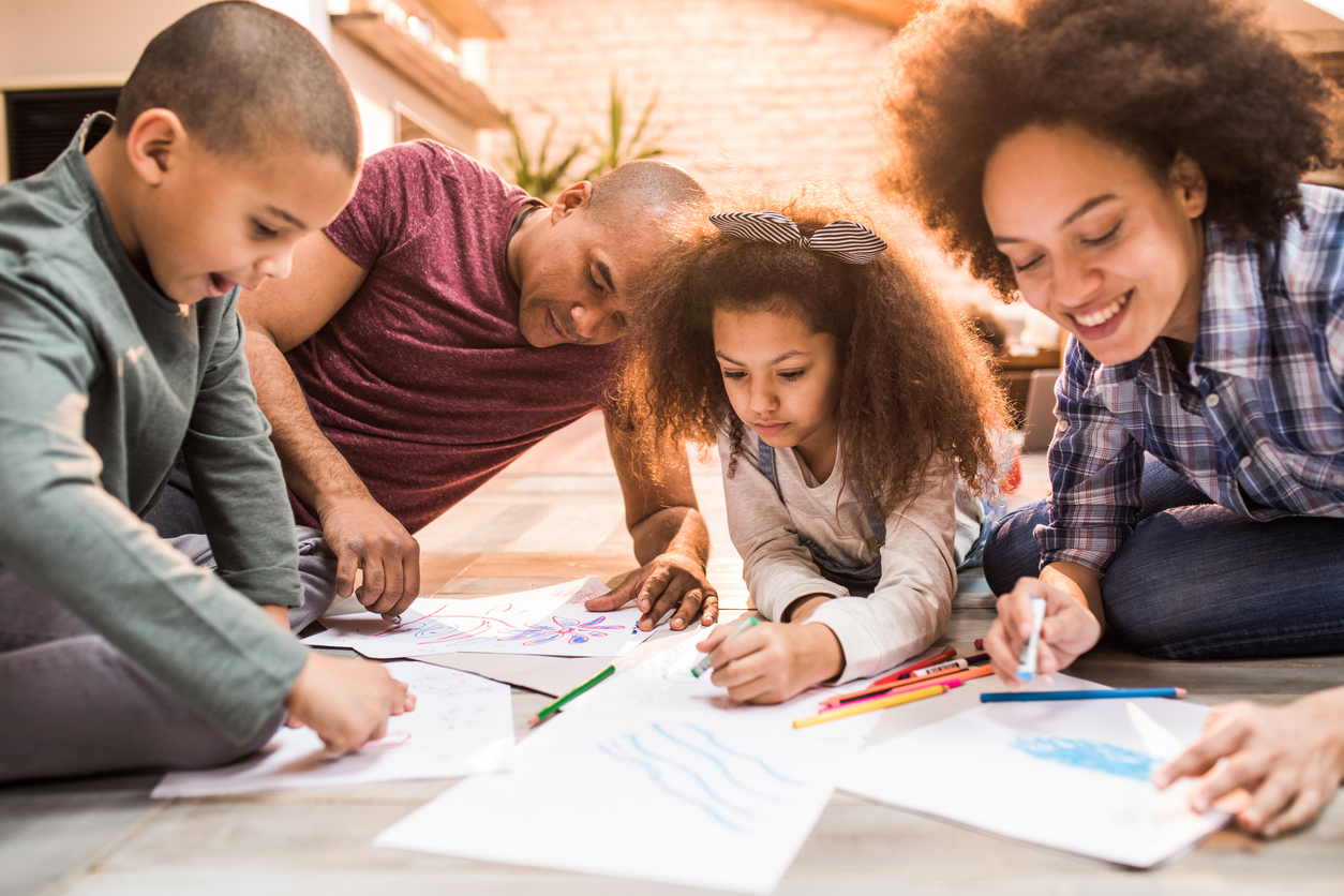 African American family drawing on floor at home.