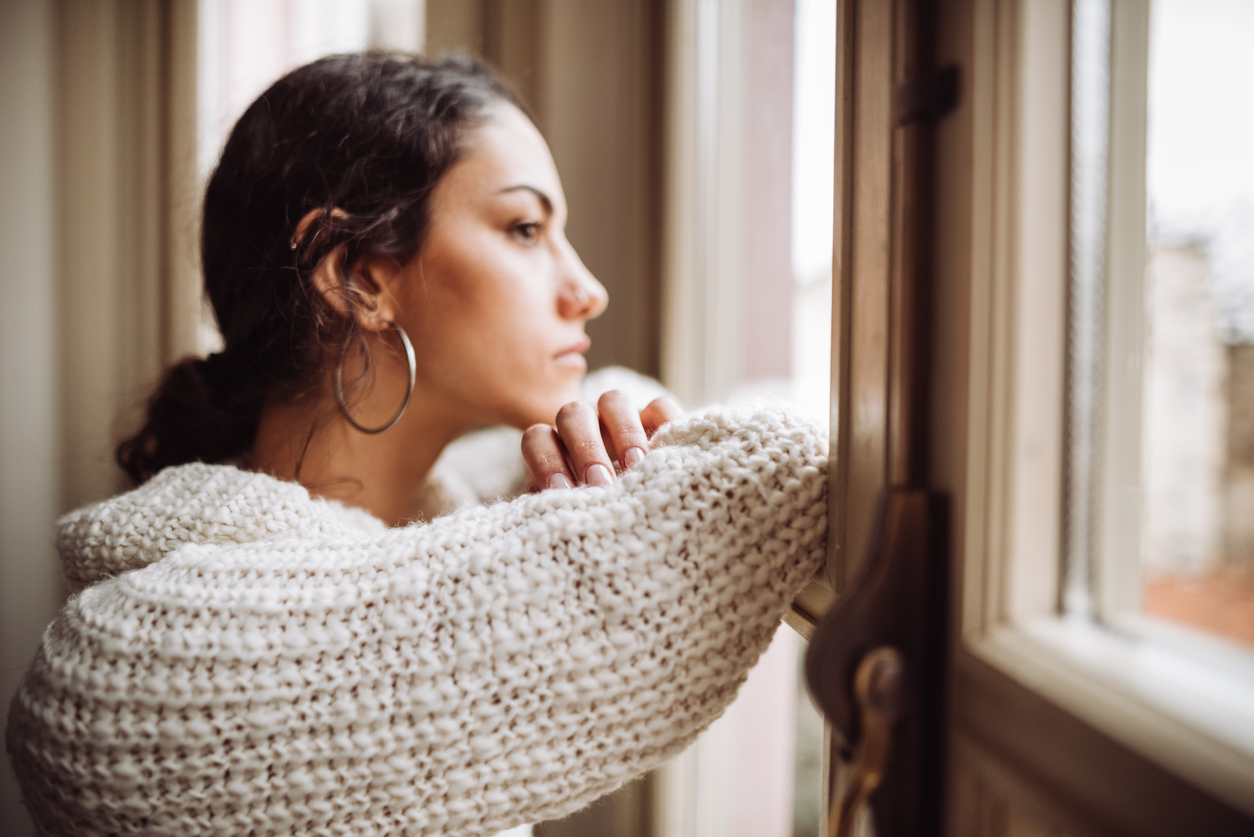 pensive woman in front of the window