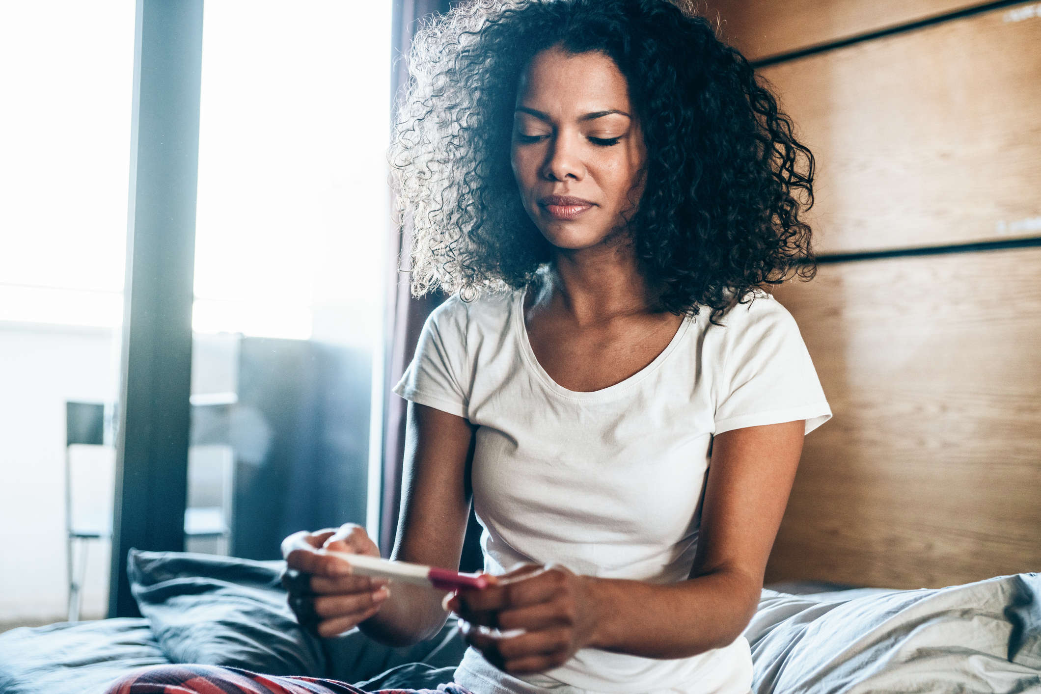 Sad Young Woman With Pregnancy Test At Home