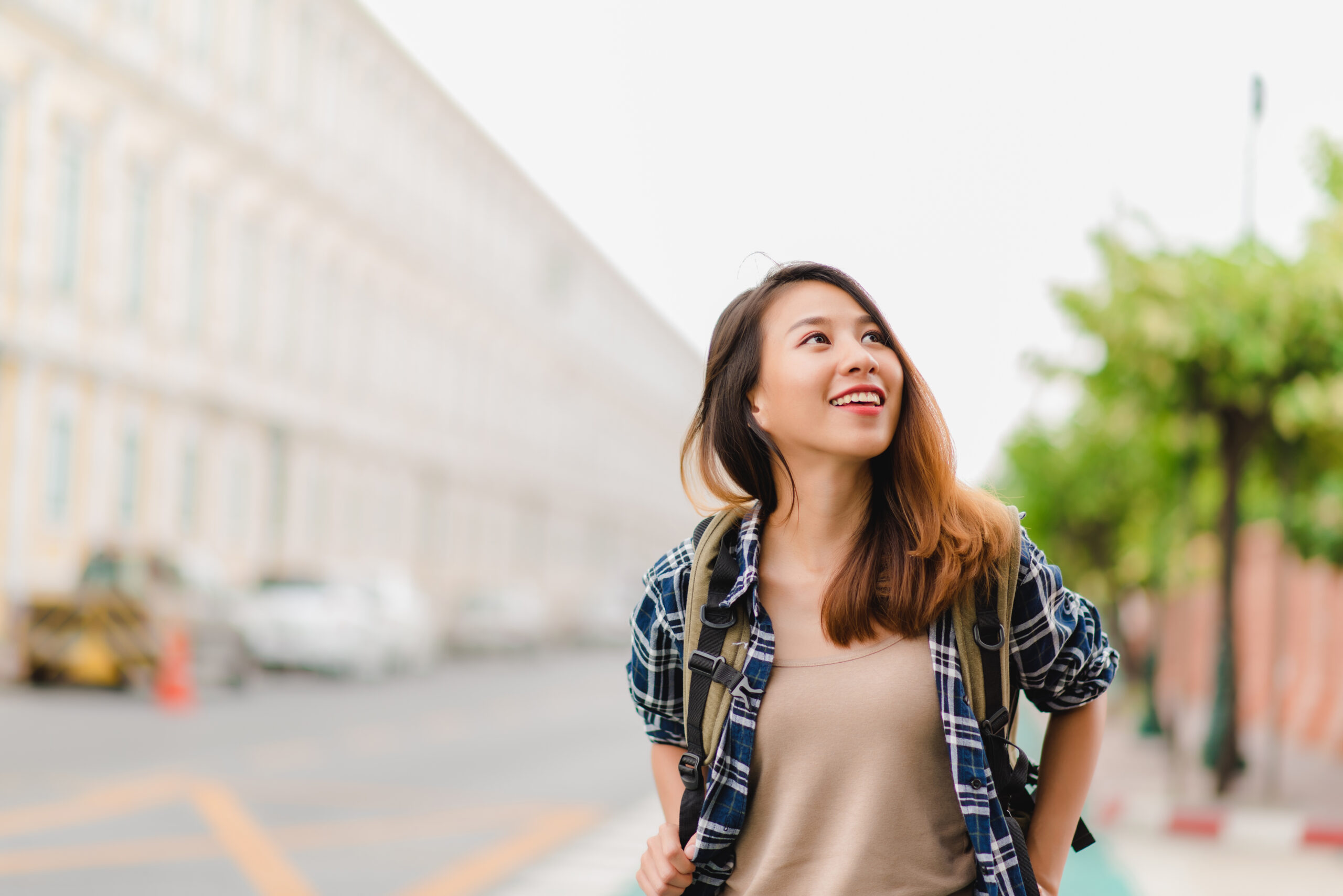 Traveler backpacker asian woman travel in Bangkok, Thailand. Happy young female spending holiday trip at amazing landmark and enjoy her journey in traditional city.