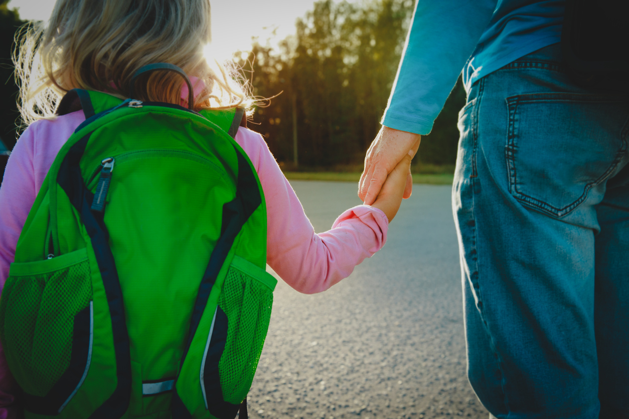 father walking little daughter to school or daycare