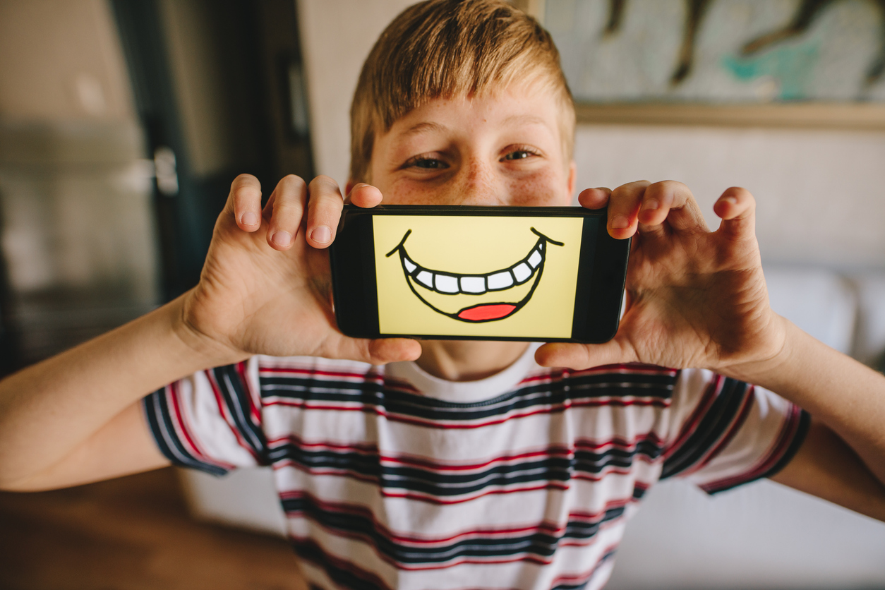 Boy with a smartphone with smiley picture