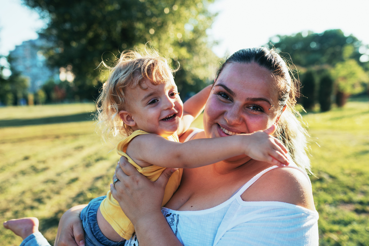 Body positive millennial mother and her son in the park