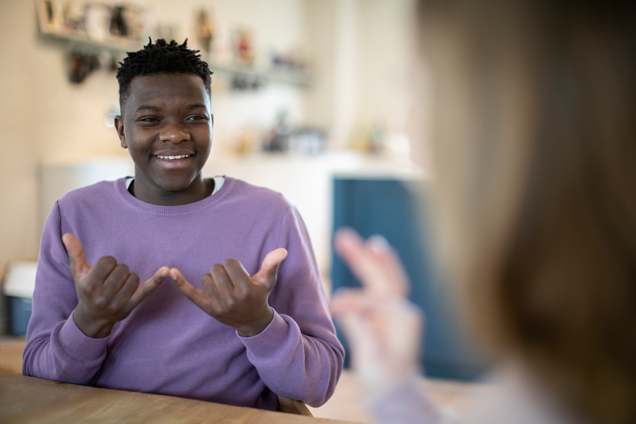 Teenage Boy And Girl Having Conversation Using Sign Language