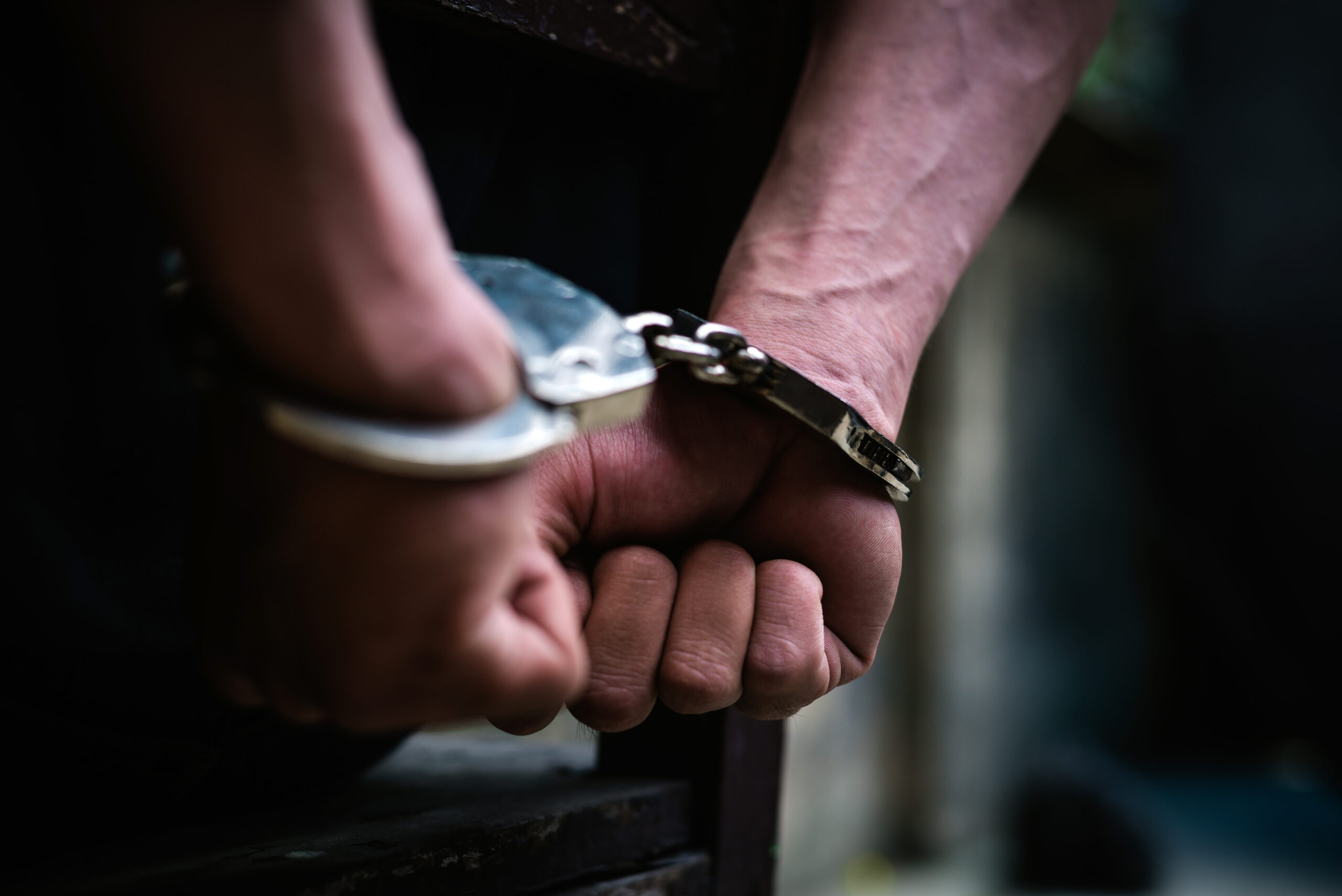 Man on the chair in Handcuffs. Rear view and Closeup