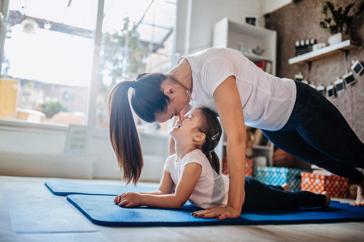 Mother and daughter working out together doing exercise at home