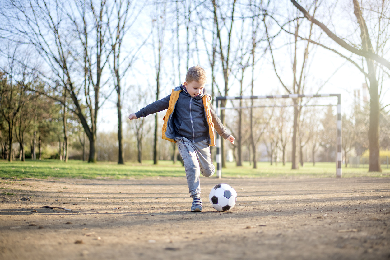 Boy play with football ball