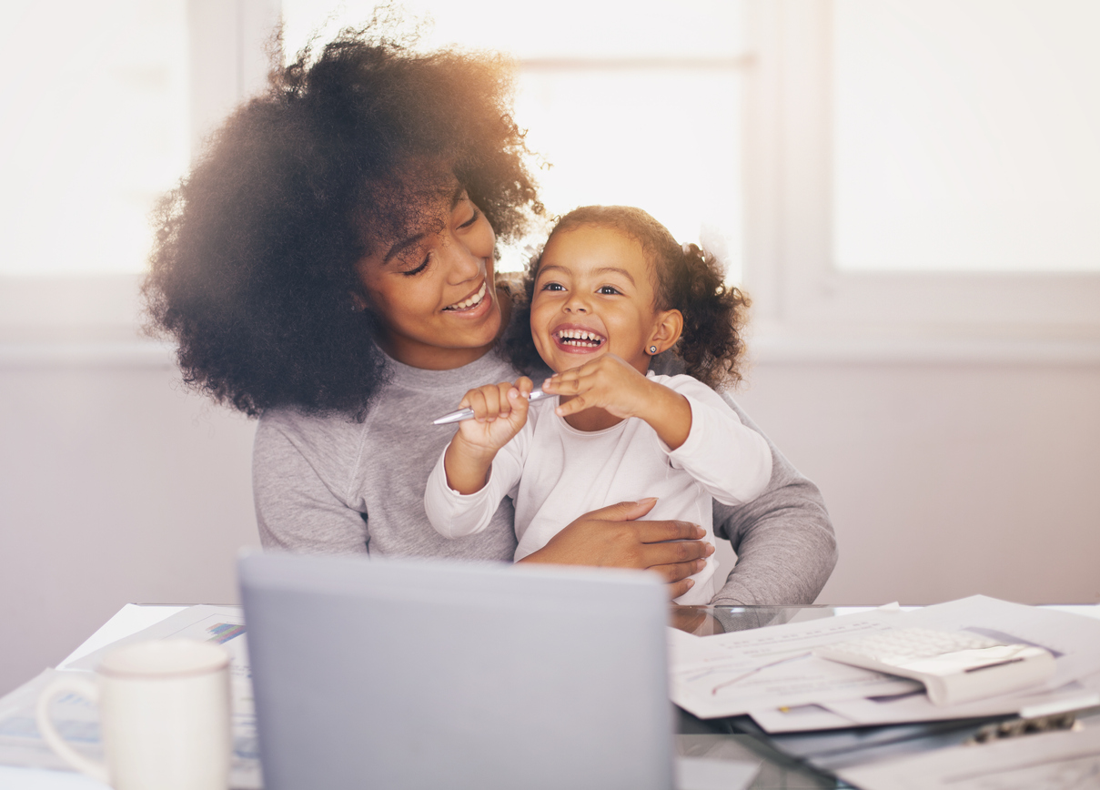 Young mother working and spending time with her daughter