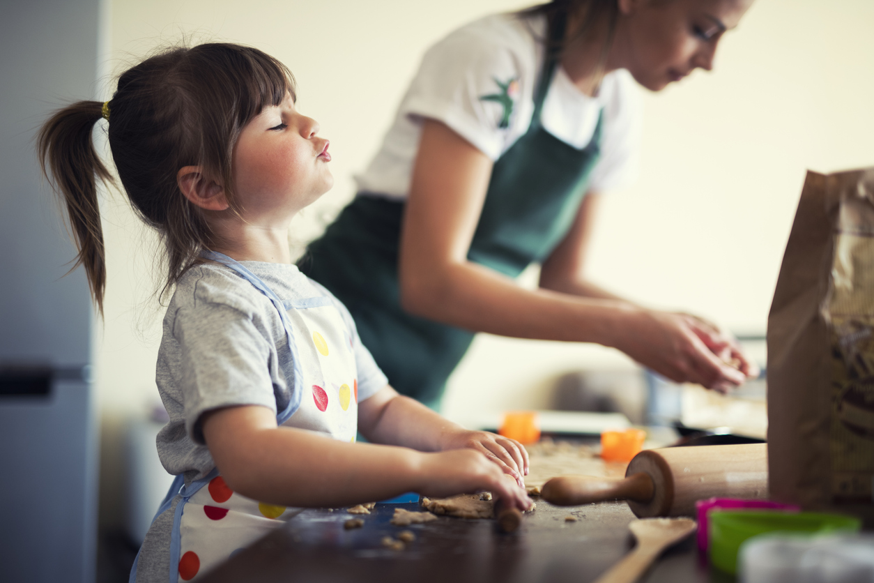 Cute little girl baking at home with mom