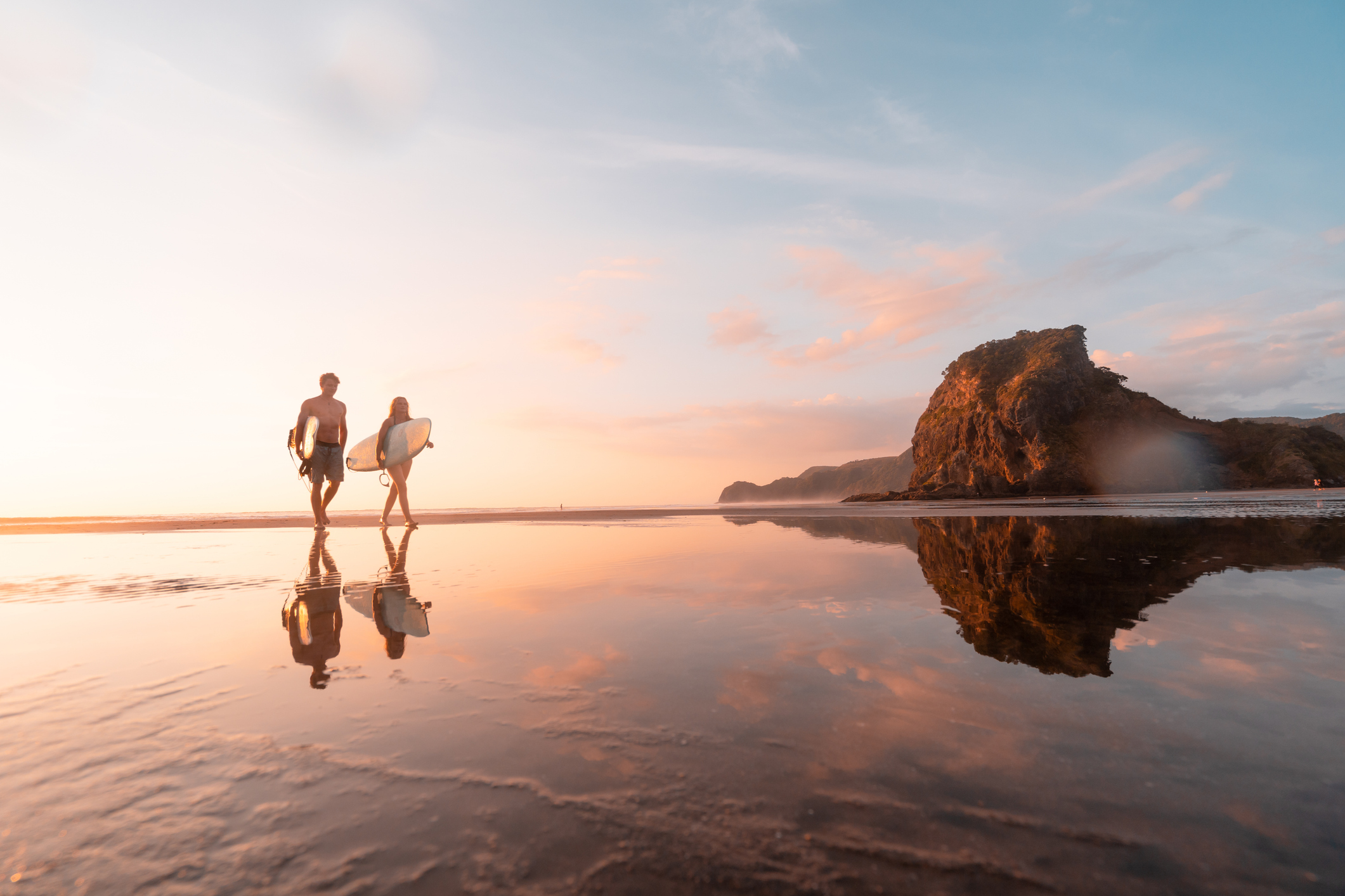 Surfer heading home at Piha Beach, Auckland, New Zealand.