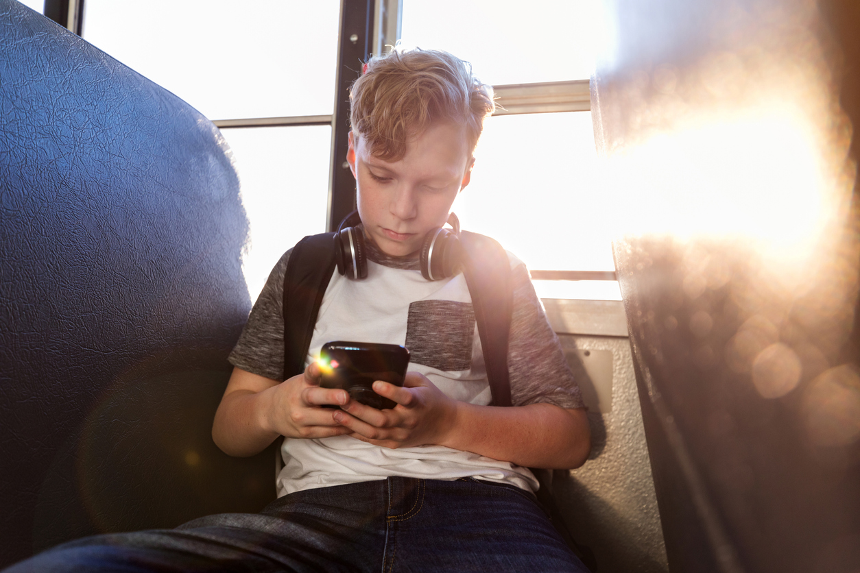 Independent young male student sits alone on bus