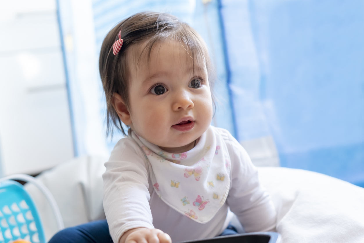 Portrait of cute baby sitting on the floor in the living room