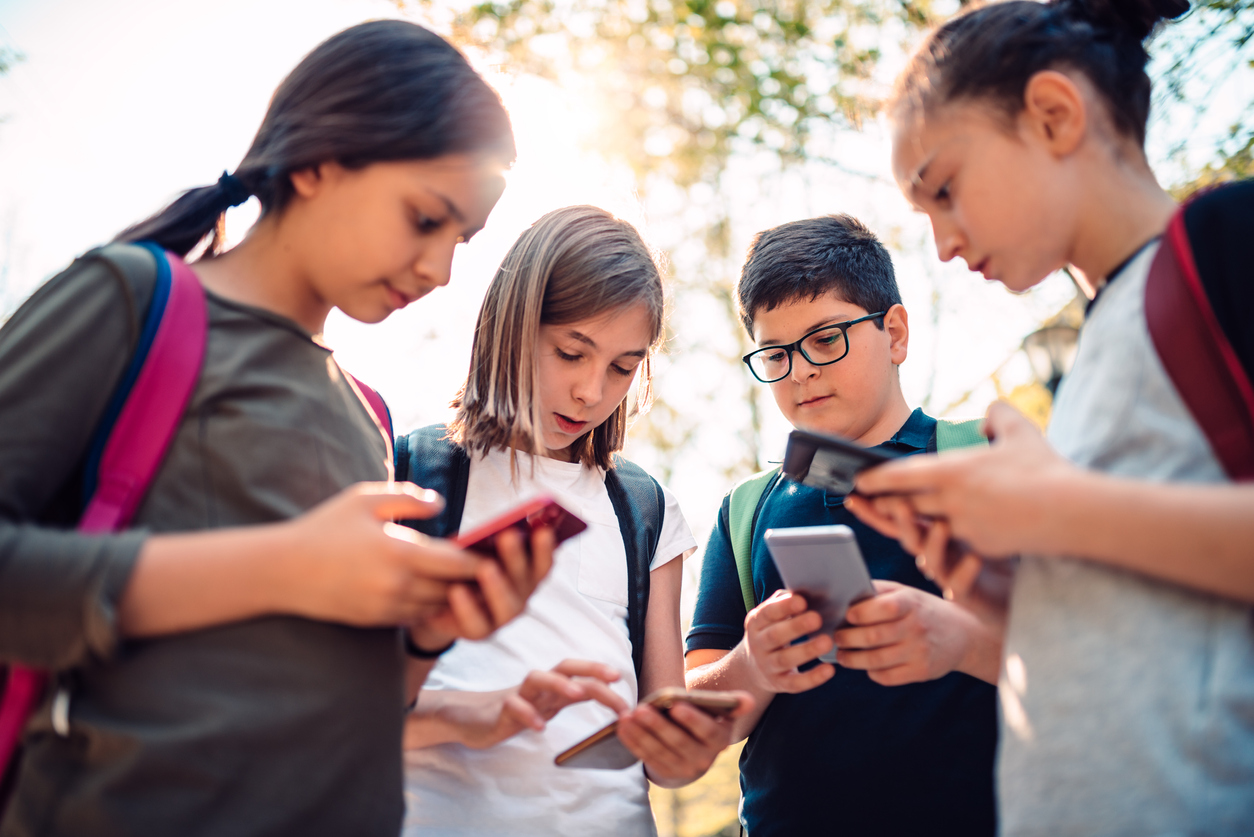 Kids playing video games on smart phone after school