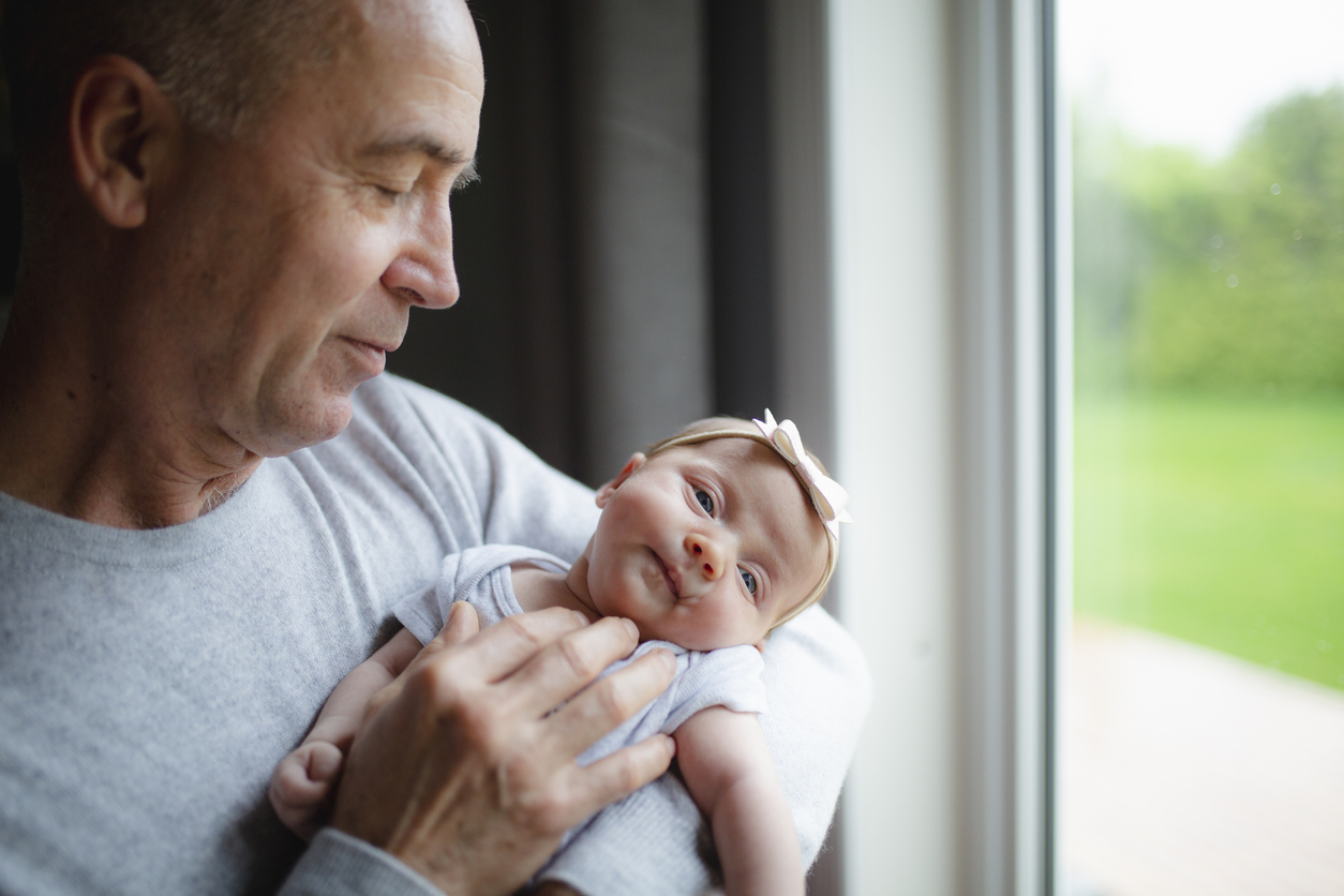 Cute newborn girl with parents and grandparents