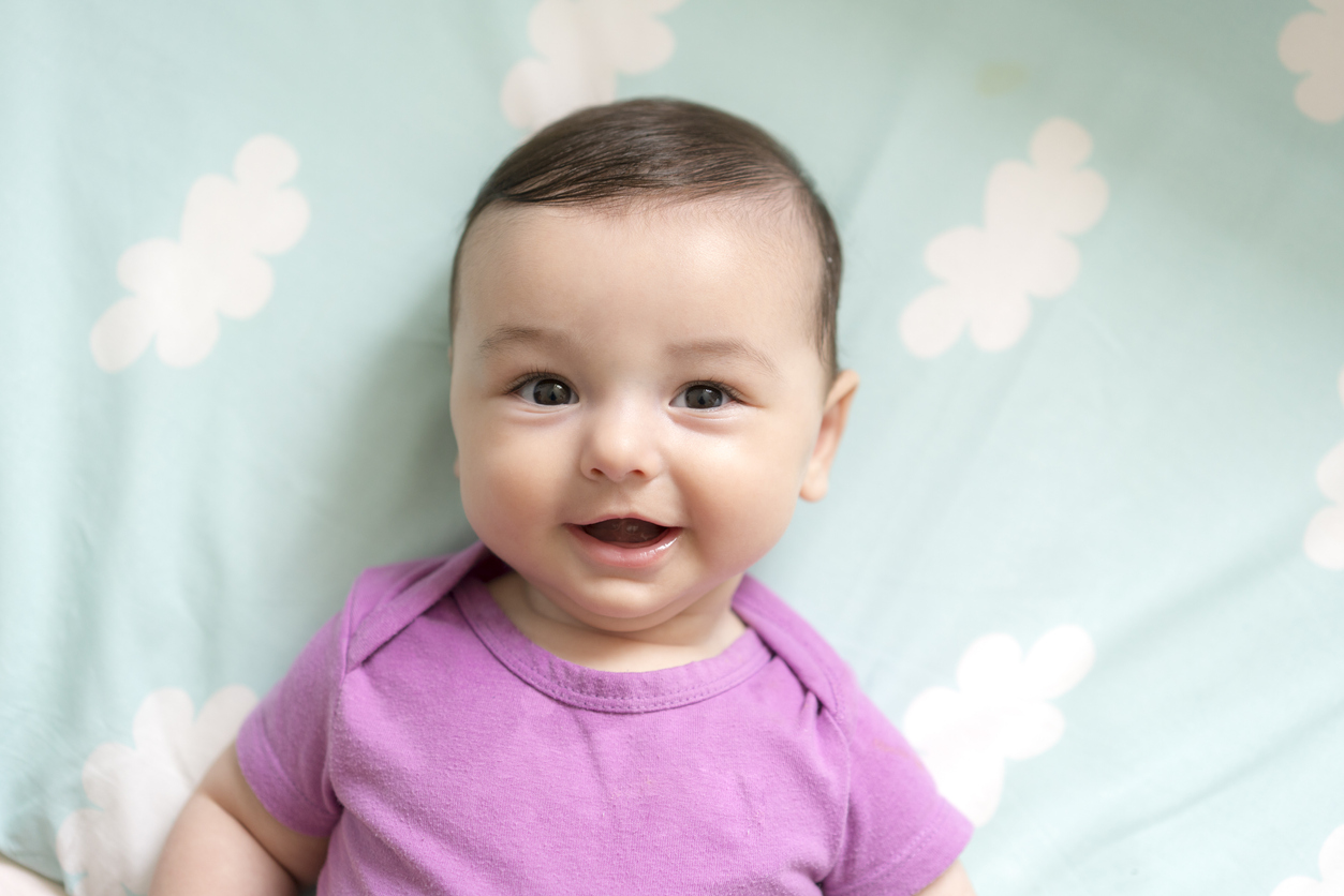 Cute baby boy lying in bed