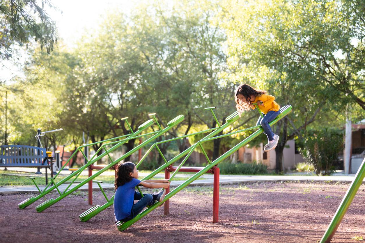 Sisters playing on a seesaw together