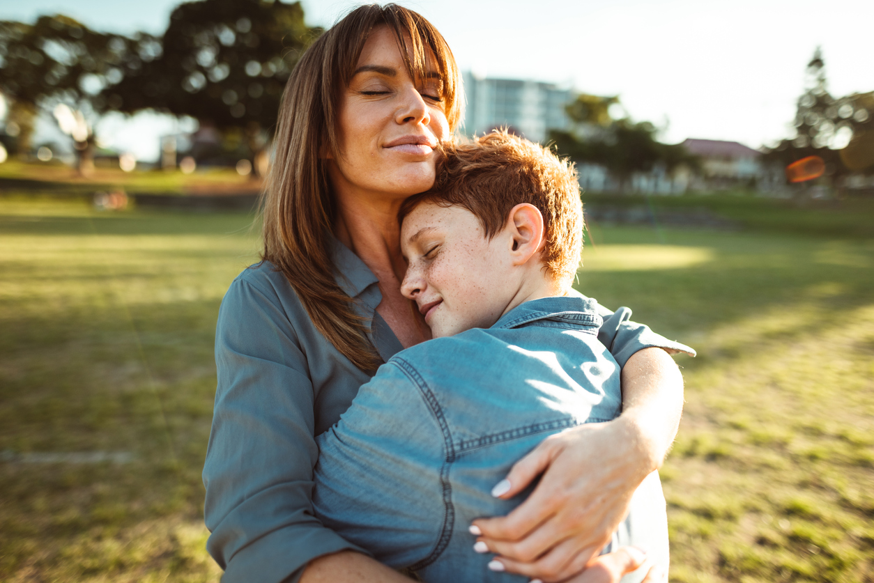 teenager embraced with mom consoling her son