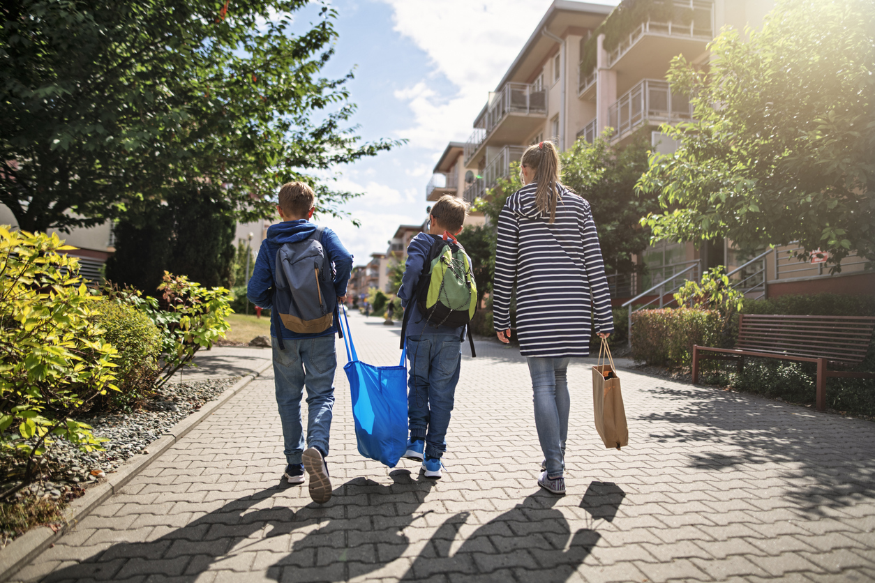 Three kids carrying shopping home in resusable shopping bags