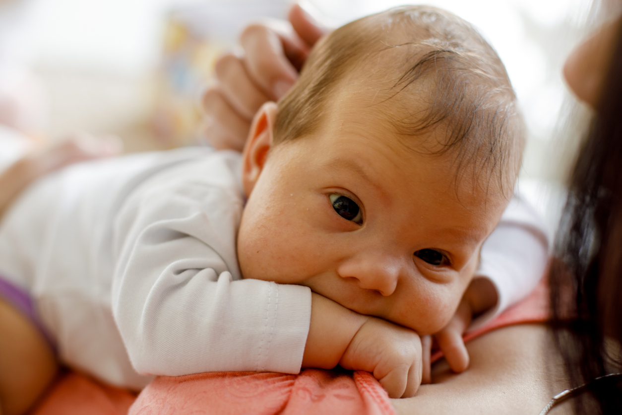 Adorable newborn baby resting on her mother's chest