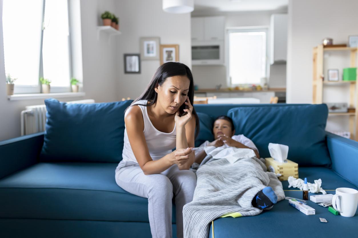 Mother Calling Doctor on the Phone because Her Sick Little Boy