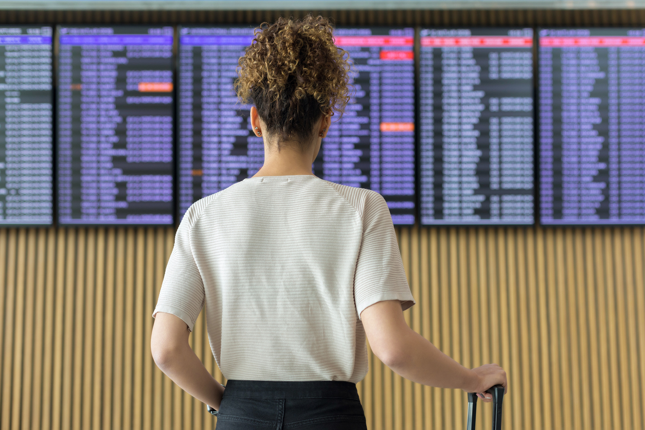 Young woman traveler looking at flight information