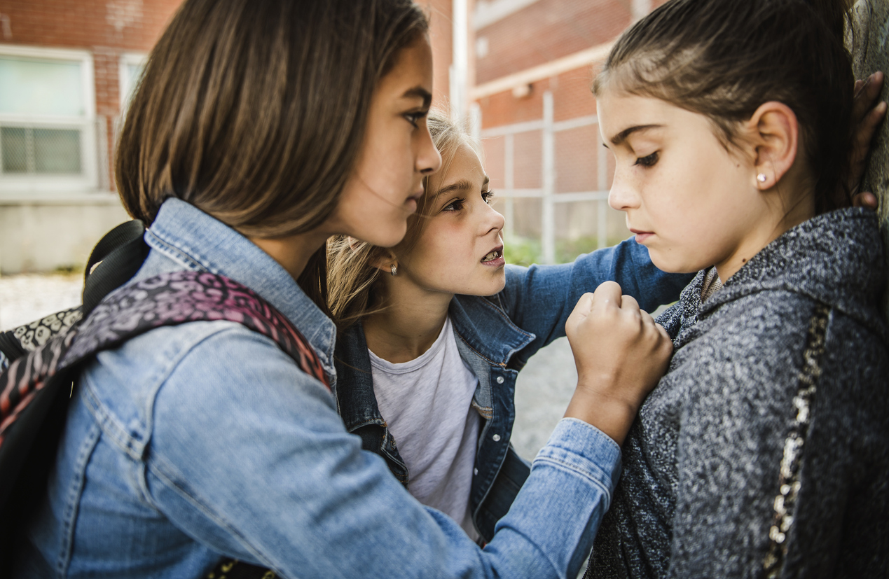 A sad girl intimidation moment on the elementary Age Bullying in Schoolyard