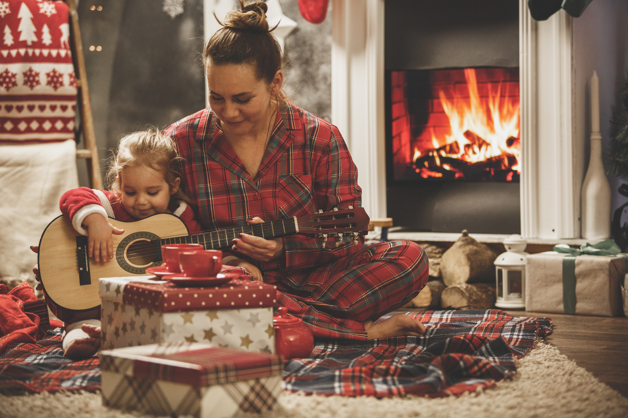 Mother and daughter playing guitar together on a Christmas Eve