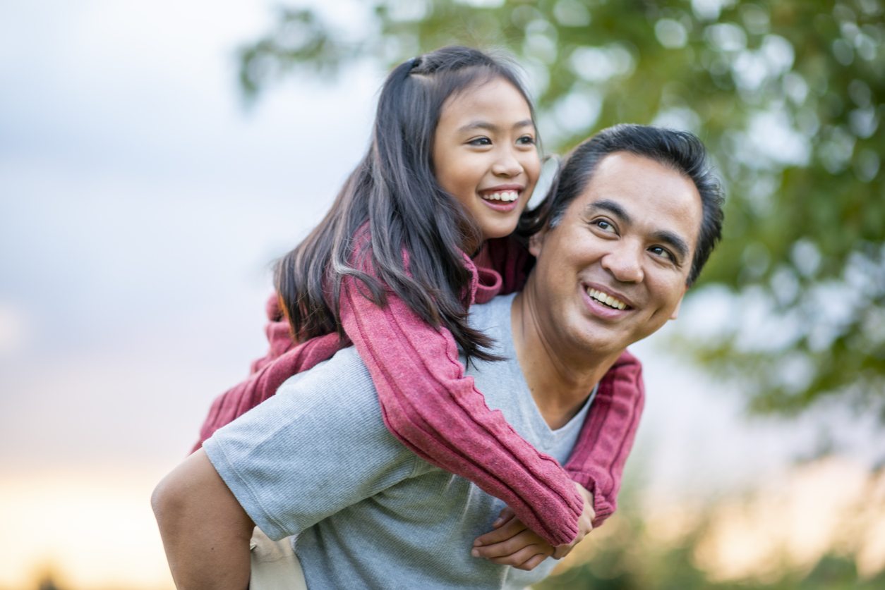 Father Giving His Daughter a Piggyback Ride stock photo