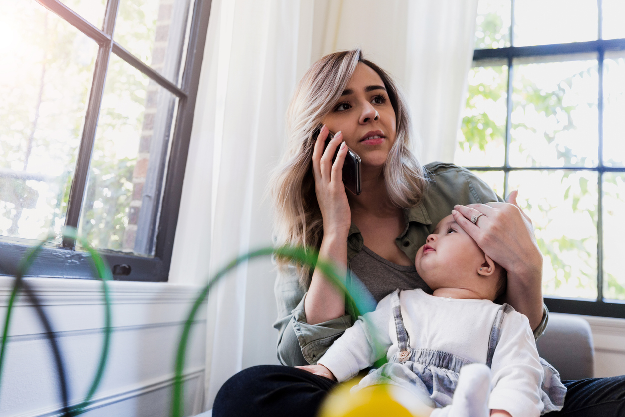 Mother uses smart phone to call doctor about baby's fever