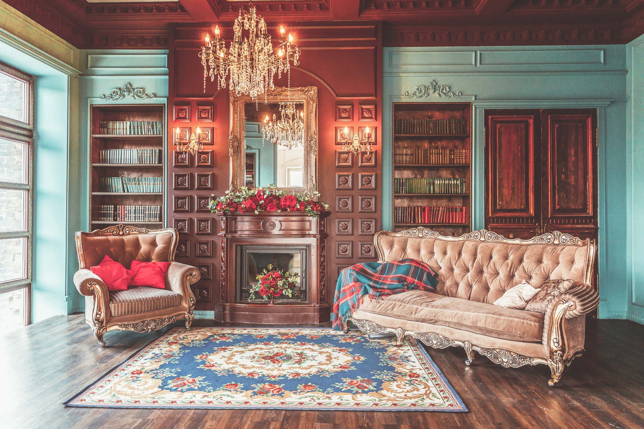 Luxury classic interior of home library. Sitting room with bookshelf, books, arm chair, sofa and fireplace