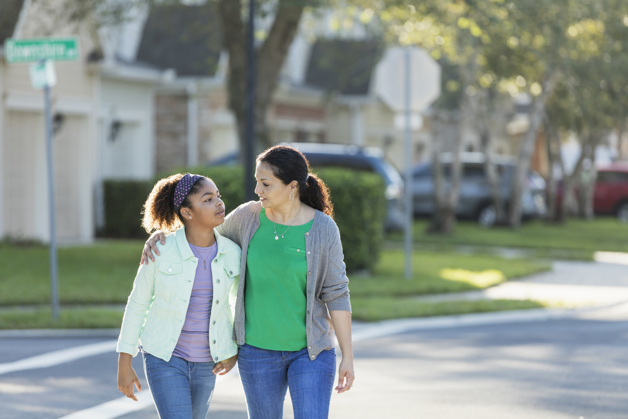 Mother and daughter walking together, talking