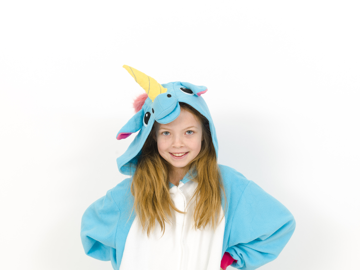 pretty blonde girl with cozy blue unicorn costume is posing