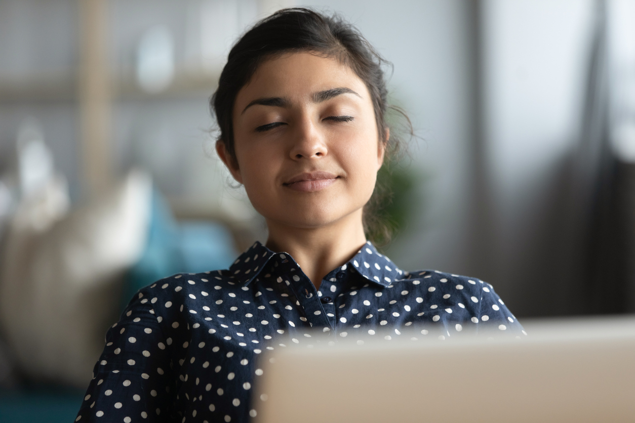 Millennial Indian woman relax at workplace taking nap